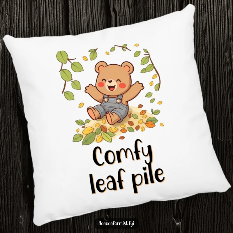 Funny pillow with a playful bear in overalls sliding down a hill of autumn leaves, a soft touch of fall.