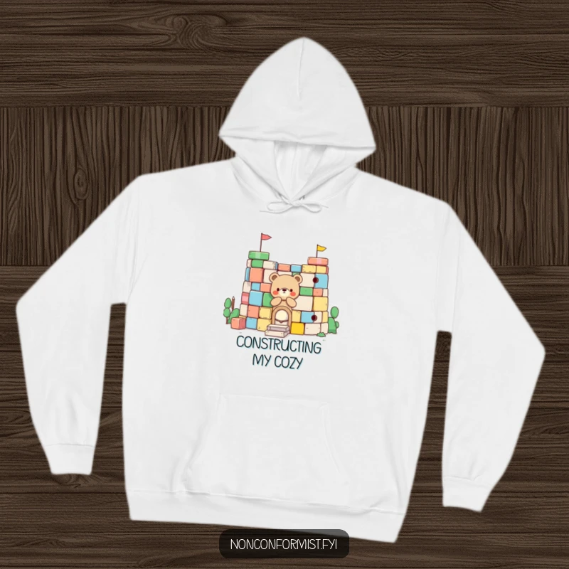 Funny Little Bear Hoodie: A charming bear character is busy building a fort with oversized colorful blocks, blending humor and coziness.