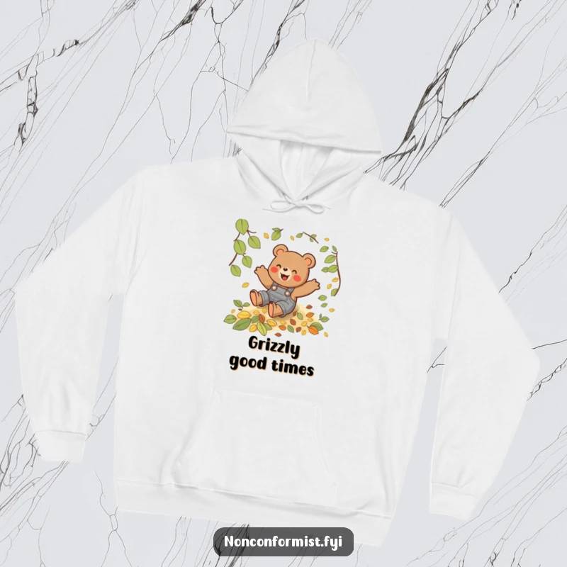 Funny hoodie featuring a playful bear in overalls sliding down a lush hill of autumn leaves with pure delight.