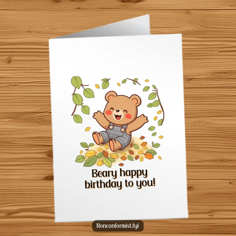 Funny free printable birthday card: a playful bear in overalls gleefully slides down a hill covered in colorful autumn leaves.