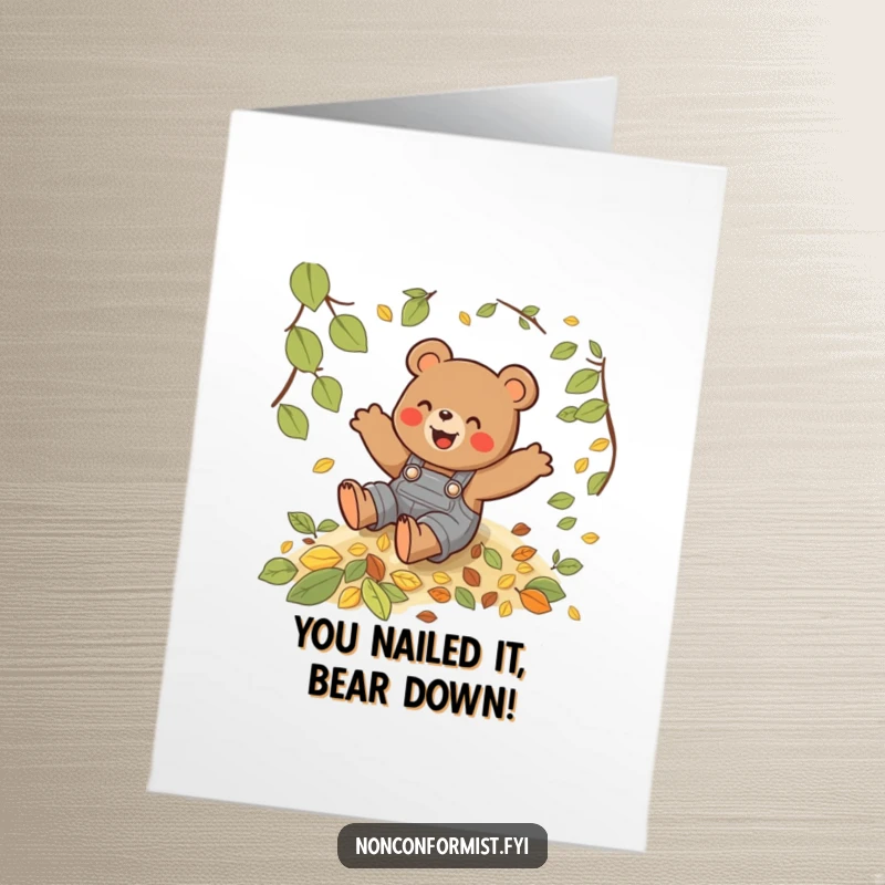 Funny free printable congratulations card: a playful bear in overalls gleefully slides down a vibrant hill of autumn leaves.